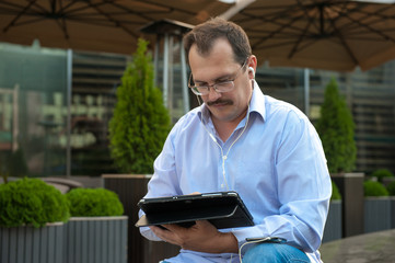 Man using tablet computer outdoors