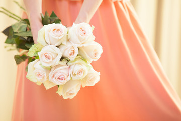 Unrecognizable young woman holding a bouquet of roses