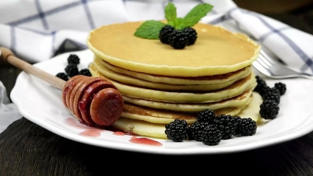 Delicious golden pancakes with fresh blackberries and raspberry jam.