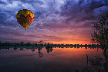 montgolfière au coucher du soleil sur le fond naturel du paysage du lac