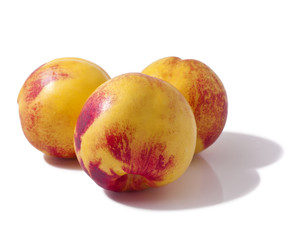 Three whole peaches isolated on white background. 