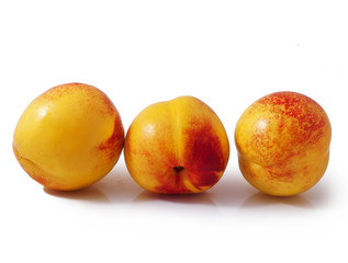 Three whole peaches isolated on white background.