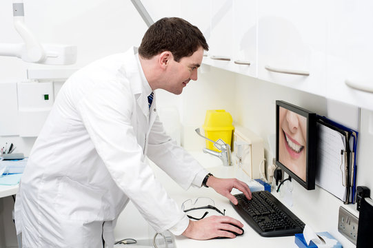 Dentist using computer in dental clinic