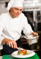 Chef arranging tossed salad in a bowl