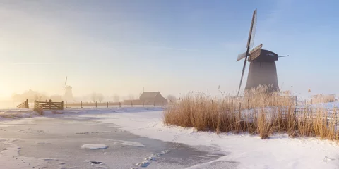 Fotobehang Dutch windmills in a foggy winter landscape in the morning © sara_winter