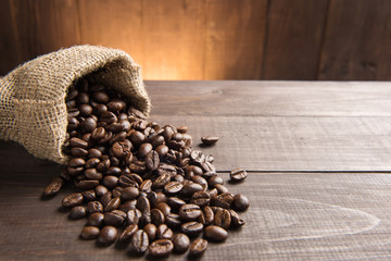 coffee beans in a bag on wooden background.