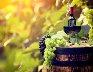 Fototapeta na wymiar Red wine bottle and wine glass on wodden barrel.