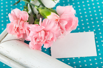Greeting card with pink carnations on a bright blue background w