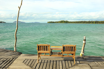 Fototapeta na wymiar Chair on Wooden pier on summer season - Wooden pier in Kho mak,