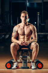 Fototapeta na wymiar Athlete muscular bodybuilder training back with dumbbell in the