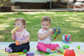 Babys, less than a year old, playing with  toys 