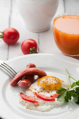scrambled eggs on a plate with pieces of tomato and sausage