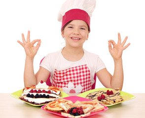 happy little girl cook with delicious crepes on table and ok han