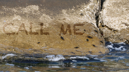 Call me scritto sugli scogli al mare