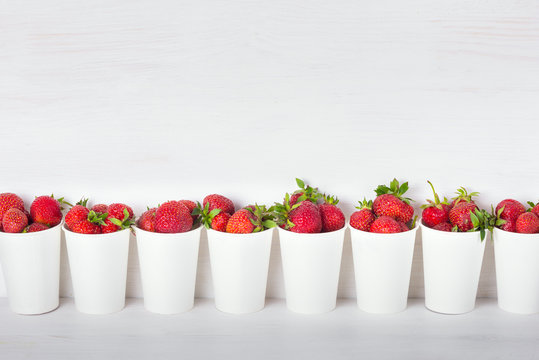 a series of white paper cups with fresh ripe delicious sweet str
