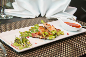 Asparagus wrapped in bacon with italian sauce