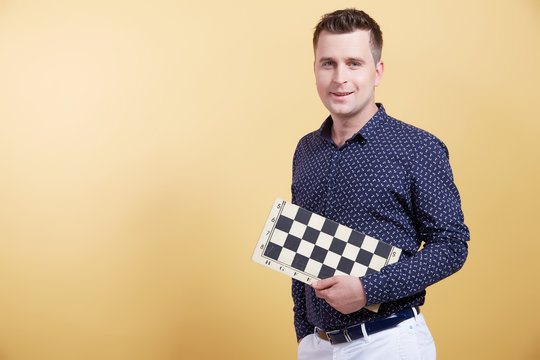 the young man with a chessboard on a yellow background