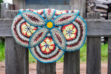 Russian vintage knitted round rug hanging on a fence