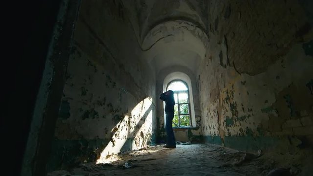 Young man in despair goes to an abandoned house. Concept: job
