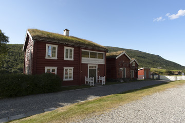 Fototapeta na wymiar Typical red scandinavian wooden house with grassy roof, Norway