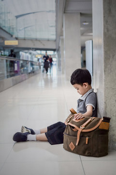 Young Boy Sitting Alone In A Hallway