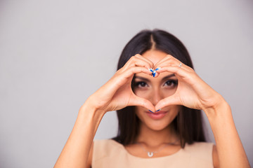 Charming woman making heart with fingers