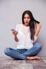 Woman sitting on the floor with smartphone