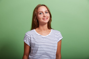 Fototapeta premium the young beautiful cheerful brunette on a green background