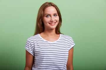 Fototapeta premium the young beautiful cheerful brunette on a green background