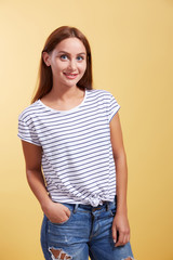 Obraz premium the red-haired beautiful young girl smiles on a yellow backgroun