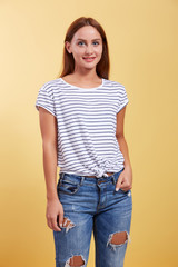 Obraz premium the red-haired beautiful young girl smiles on a yellow backgroun