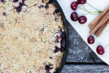 Homemade Cherry crumble and cherries on an old wooden table background.Selective focus.
