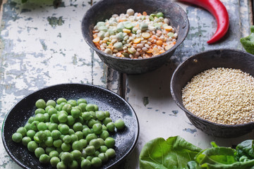 Quinoa Burger ingredients: quinoa, mangold, dry grain mix, chili pepper, eggs green peas basil on white rustic board