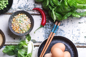 Quinoa Burger ingredients: quinoa, mangold, dry grain mix, chili pepper, eggs green peas basil on white rustic board