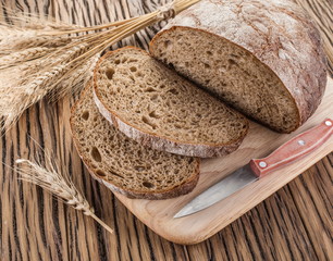 Sliced black bread on the wooden plank.