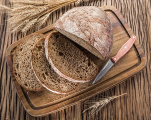 Sliced black bread on the wooden plank.