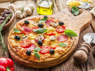 Pizza with mushrooms, salami and tomatoes.