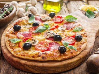Pizza with mushrooms, salami and tomatoes.