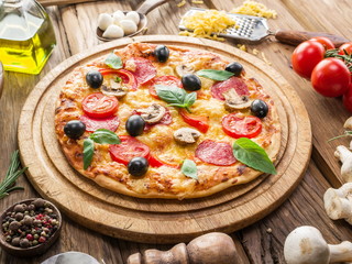 Pizza with mushrooms, salami and tomatoes.