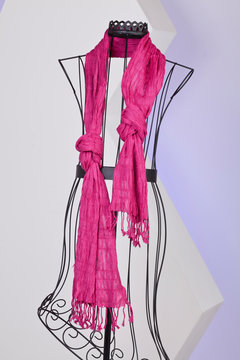 pink scarf woven with fringes on a mannequin