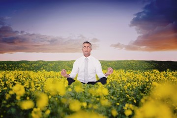 Composite image of zen businessman meditating in lotus pose 