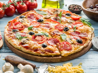 Pizza with mushrooms, salami and tomatoes.