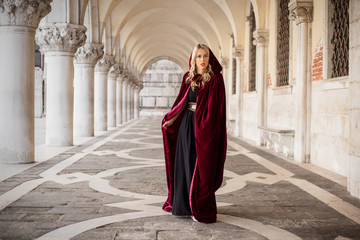 Naklejka premium Woman in red cloak standing at Doge's Palace in Venice