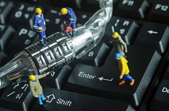 miniature people try to unlock metal security lock key