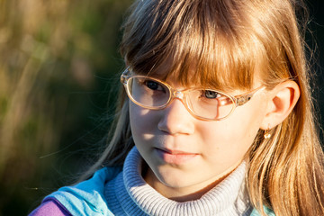 Smiling little blond girl with glasses