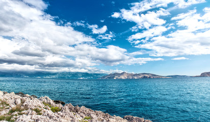 Panoramic view of island coastline landscape, calm water, clear sky on a sunny vacation day. Seaside resort as exotic destination