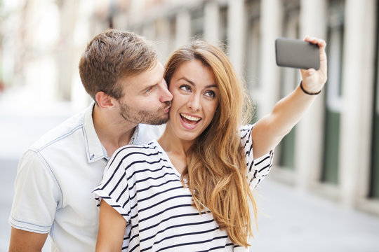 Portrait of a happy couple making selfie photo with smartphone
