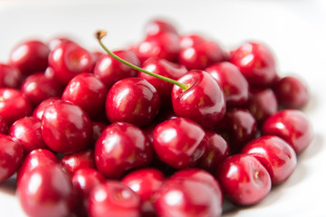 Bowl of red fresh cerries on a white background