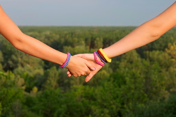two children's hands with bracelets