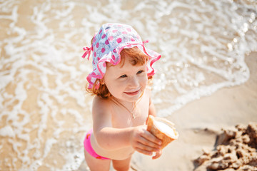 little girl eating ice cream on beach vacation